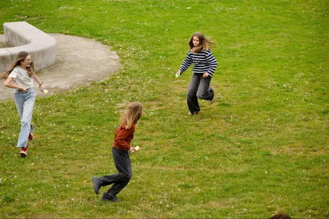 Kinderen rennen over een grasveld met Picoo-controllers in hun hand